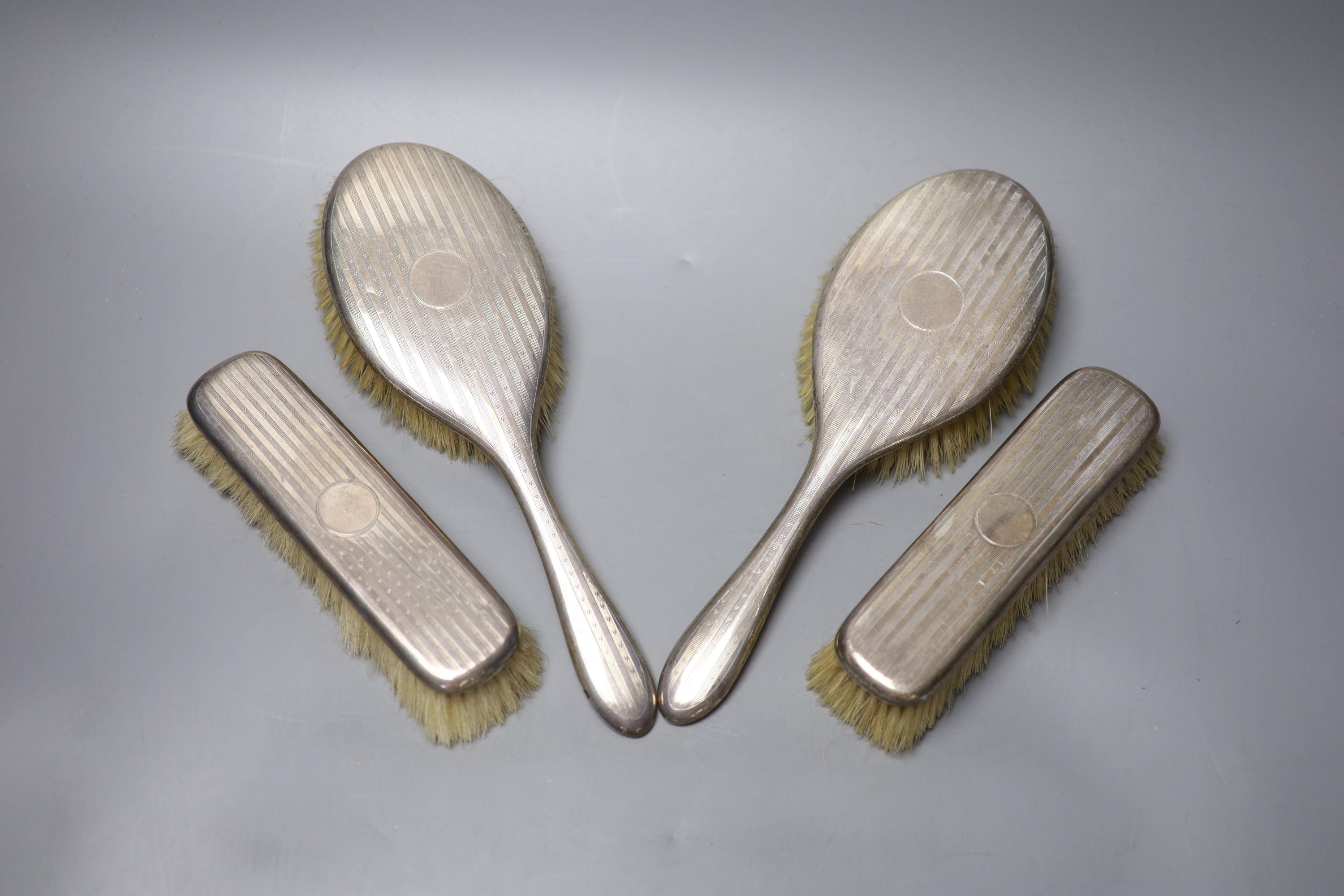 A Victorian engraved silver goblet, London, 1875, 6.3cm, a pair of silver sugar tongs and four silver mounted brushes.